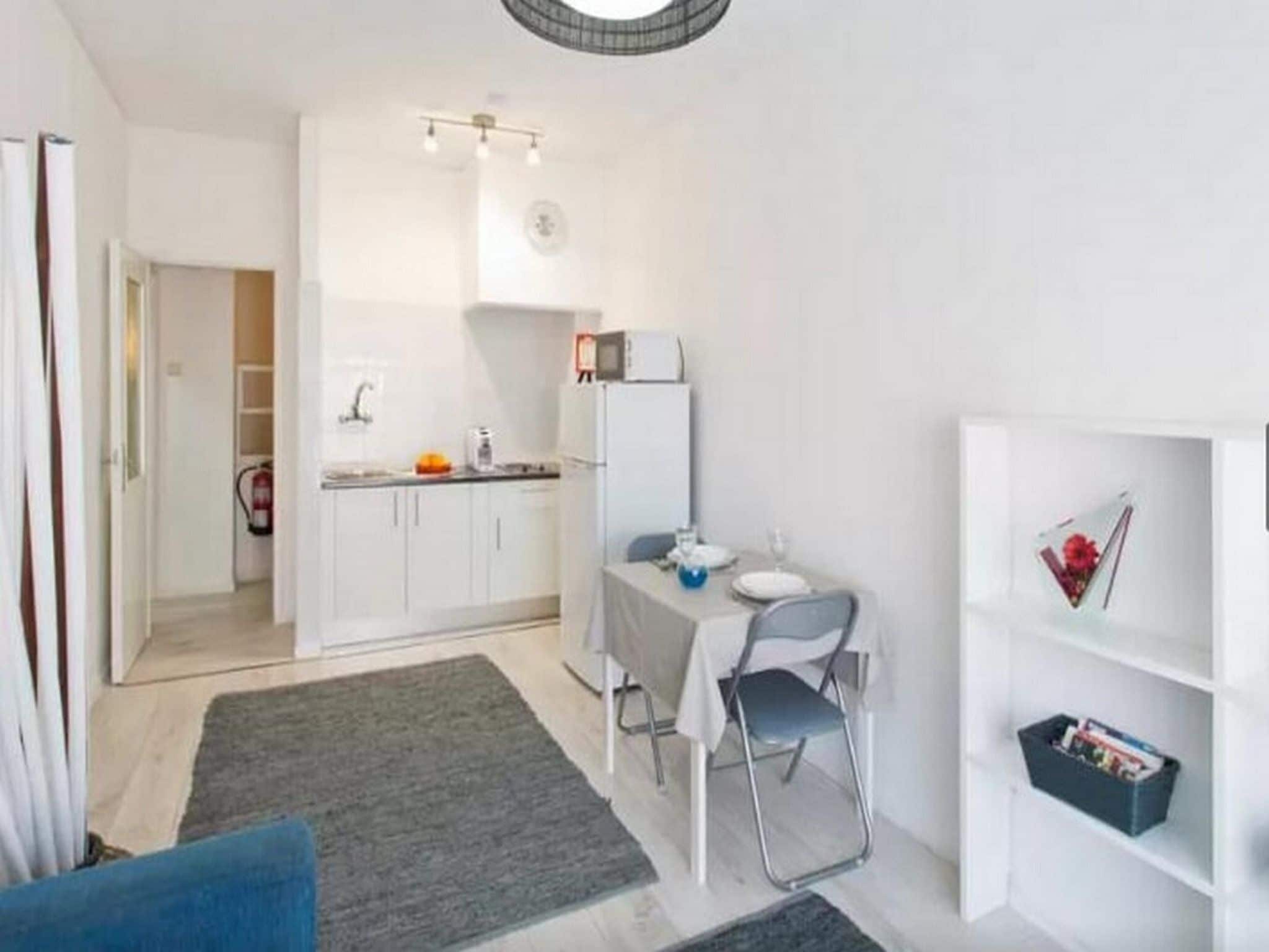 A compact living space with a kitchenette, a dining area, and a small seating area.