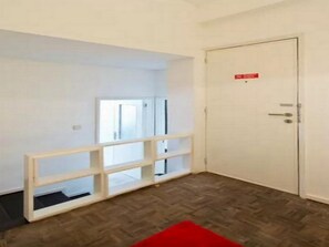A room with a herringbone-patterned floor, a white door with a red sign, and a white-framed window. - Sunny Apartment In City Center (Porto)