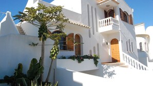A white building with a wooden door, balconies, and a staircase. - Large Villa in a relaxing area, with a private Pool and great Sea view. (Forte de São João)