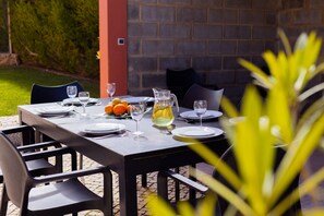 Enjoy a casual meal in our garden patio area, where a table for four is set with fine tableware and a refreshing pitcher of water.