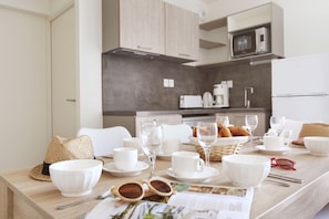 Eine moderne Küche mit weißen Schränken, einer Kaffeemaschine und einer Mikrowelle.