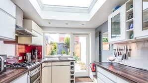 Een moderne keuken met dakraam, inbouwapparatuur en uitzicht.