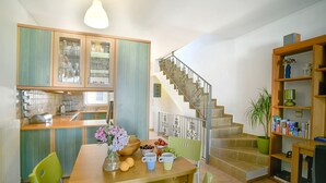 Une cuisine avec une table à manger, des chaises et un escalier menant à un niveau supérieur.