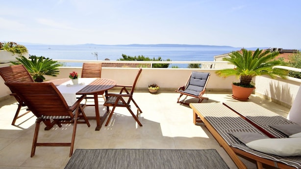 A terrace with a table and chairs, a lounge chair, and potted plants. - Cosy apartment for 5 people with WIFI, A/C, pool, TV, terrace and pets allowed (Solin)