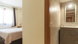 A bedroom with a bed, a nightstand, and a lamp. The room has a window with curtains. - NEW APARTMENT CLOSE TO THE BEACH 2 (Tossa de Mar)