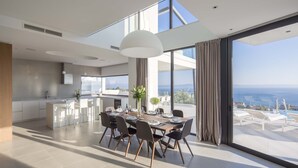 A modern kitchen with a dining area, large windows, and a view of the sea. - 5*Familiy Villa,Seaview,Indoor&Outdoor Heated Pools (Makarska)