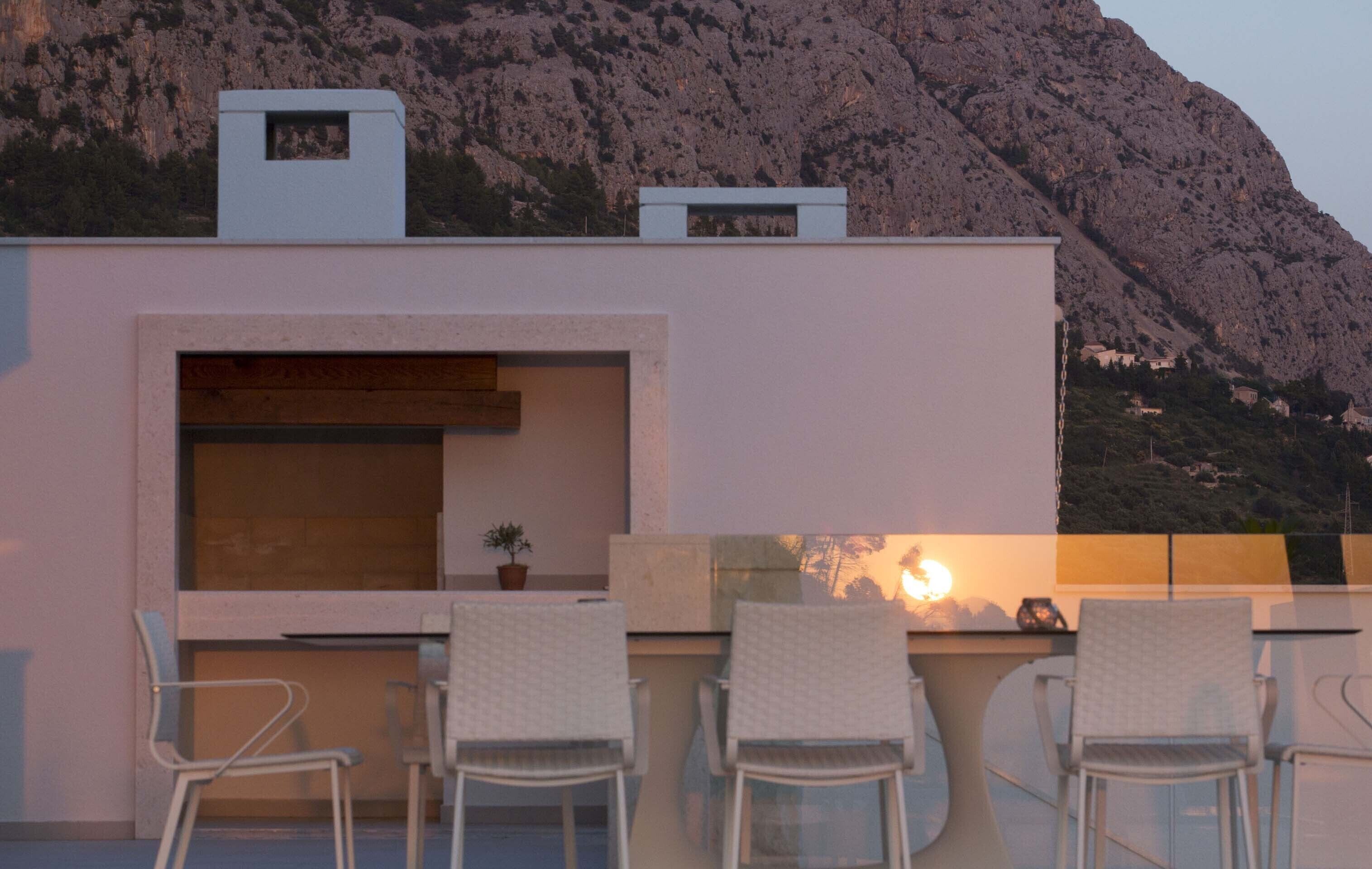 Una terrazza sul tetto con angolo salotto, un tavolino e una pianta in vaso.