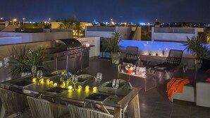 An outdoor dining area with a grill, seating, and a view of the city at night. - Luxury Villa Pool, 10 mins Walk to Beach & Golf near by (San Pedro del Pinatar)