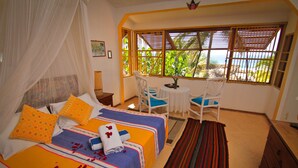 Un dormitorio con dos camas, una mesita y una silla.