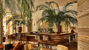 A cozy bar area with wooden furniture, a bar counter, and large potted plants. - Santa Monica Proper Hotel, a Member of Design Hotels (Santa Monica)