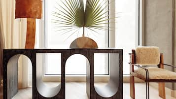 Un interior moderno con una mesa de madera, una planta en maceta y un sillón mullido.