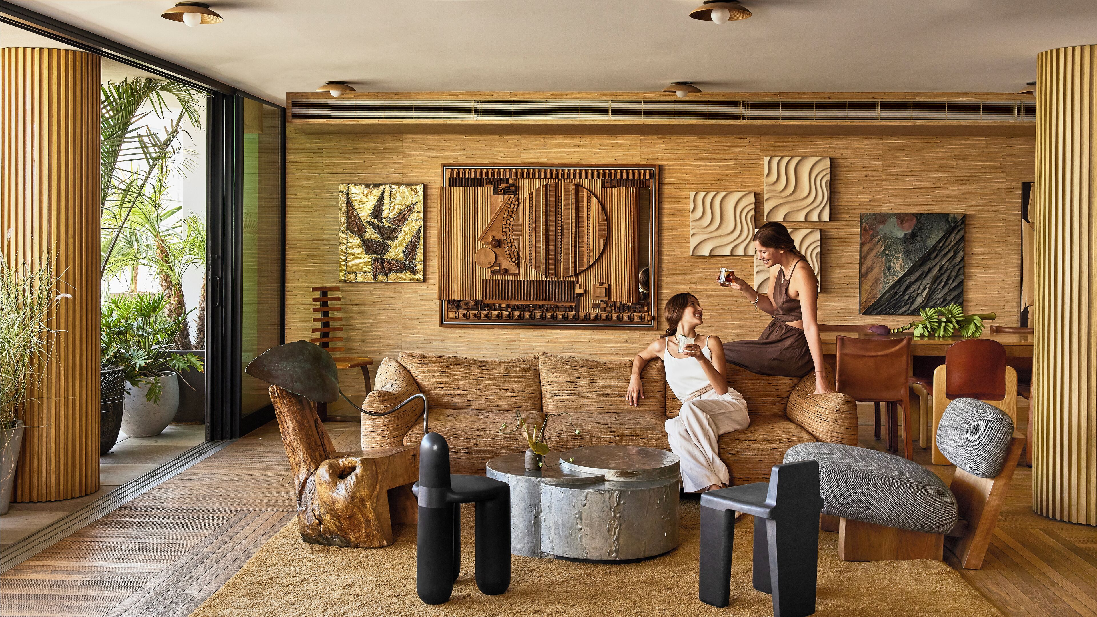 A modern living room with a wooden wall, a large abstract painting, and a coffee table.