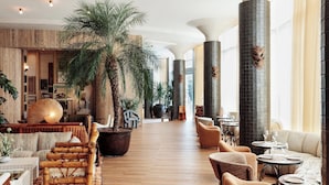 A spacious lobby with a large palm tree, seating areas, and a modern design. - Santa Monica Proper Hotel, a Member of Design Hotels (Santa Monica)
