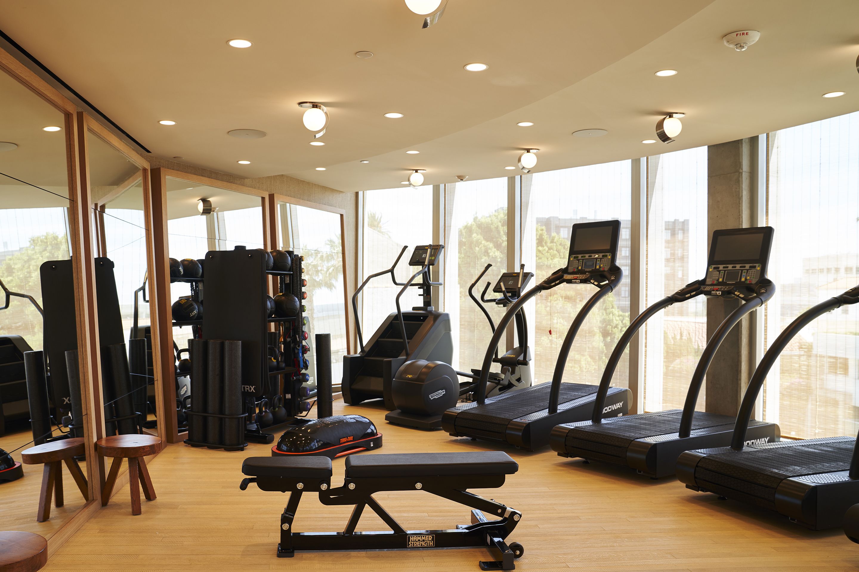 A gym with treadmills, a bench, and weight machines.