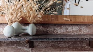 A marble countertop with a vase of dried pampas grass and a decorative bone-shaped object.