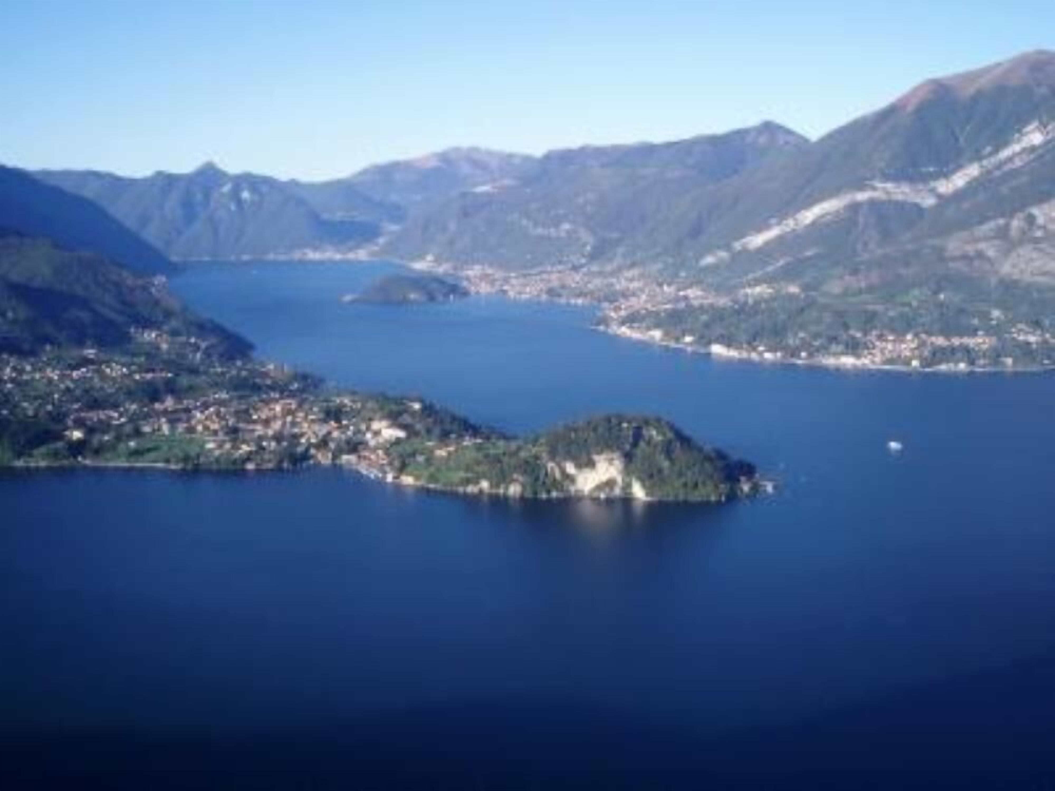 A coastal town with a central island, surrounded by mountains and a large body of water.