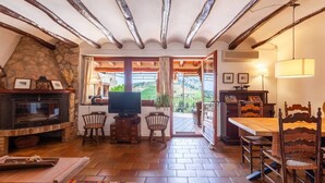Una sala de estar acogedora con chimenea, televisión y comedor.