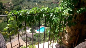 Vista desde un balcón con piscina, rodeado de vegetación y paisaje rural.
