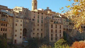Un edificio histórico de varias plantas, con una destacada torre de reloj y ventanas arqueadas.