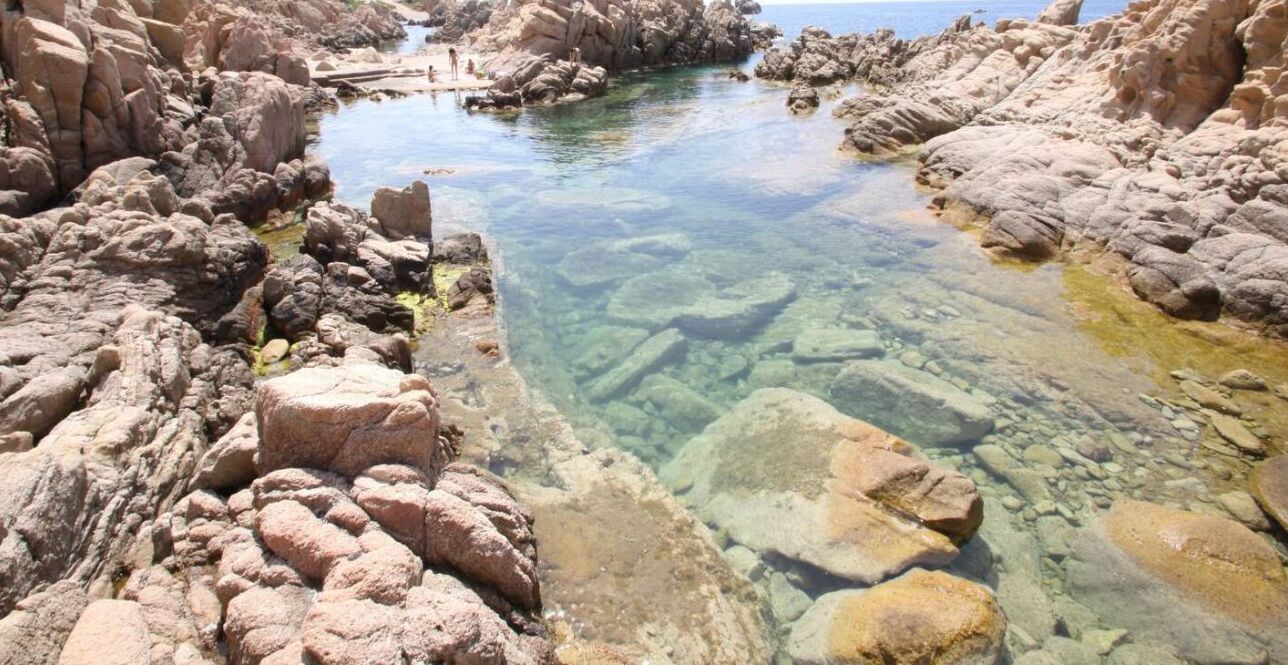 Eine felsige Küstenlandschaft mit klarem Wasser und großen Felsen.