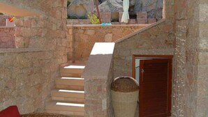 A stone staircase leading to a wooden door, with a wicker basket and a towel hanging nearby.