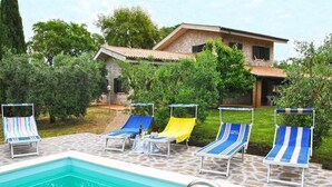 A swimming pool with lounge chairs and a stone patio. - Villa Il Casolare Country House with pool (Itri)