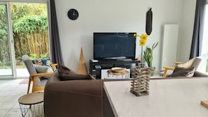 Un salon moderne avec un canapé, une table basse et un téléviseur.