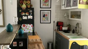 A modern kitchen with a wooden countertop, a sink, and a built-in cat house.