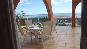 Terrassa amb taula preparada per dinar, amb vista a la costa.