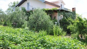 A house with a sloped roof, a balcony, and a garden with various plants. - Large Rental House. Adriatic Seaside (Turanj)