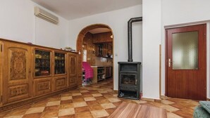 A spacious living area with a checkered floor, wooden cabinets, a fireplace, and an arched doorway leading to a kitchen. - Large Rental House. Adriatic Seaside (Turanj)