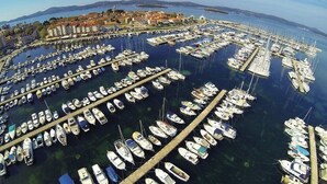 An aerial view of a marina with numerous boats docked in a circular pattern, surrounded by buildings and a clear sky. - Large Rental House. Adriatic Seaside (Turanj)