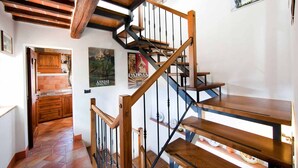 A wooden staircase with a black railing leading to a landing. - Awesome 1BR Countryside Tower Suite w shared pool & gorgeous gardens (Cortona)