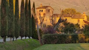 A stone building with a traditional design, surrounded by neatly trimmed trees and a well-maintained garden. - Awesome 1BR Countryside Tower Suite w shared pool & gorgeous gardens (Cortona)