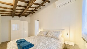 A bedroom with a bed, a wardrobe, and a nightstand. - New apartment in Murano the amazing glass island (Venezia)