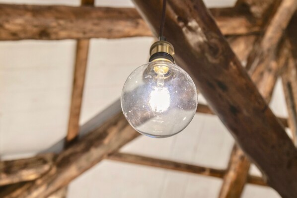 A clear light bulb hanging from a wooden structure. - New apartment in Murano the amazing glass island (Venezia)
