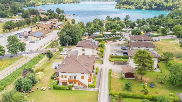 Ein Wohngebiet mit Häusern, einer Straße und einem See.