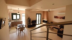 Un grand espace de vie comprenant une table à manger, des chaises, un canapé et un téléviseur.