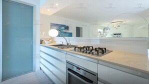 A modern kitchen with a built-in oven, a sink, and a countertop with a mirror above it. - Beautiful beach with Private Pool Villa in Castellammare del Golfo (Castellammare del Golfo)