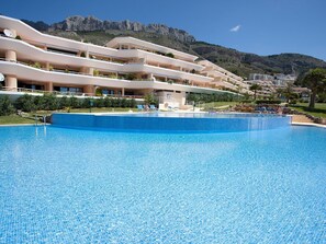 A hotel with a large swimming pool, multiple balconies, and a mountainous backdrop. - Lovely apartment for 4 guests with A/C, WIFI, pool, TV, terrace and panoramic view (Altea)