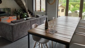 Un salon confortable avec un canapé, une table à manger et un escalier.