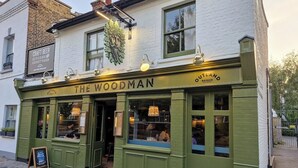 A green pub named "The Woodman" with a sign indicating it serves craft beer and pizza. - Fabulous one double bedroom flat in garden setting by the river in Battersea (London)