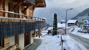 A wooden building with a balcony, a snow-covered path, and a mountain backdrop. - Superb chalet: 50m to ski lift. 6 large bedrooms, sleeps 12, sauna & steam rooms (Saint-Jean-D'aulps)