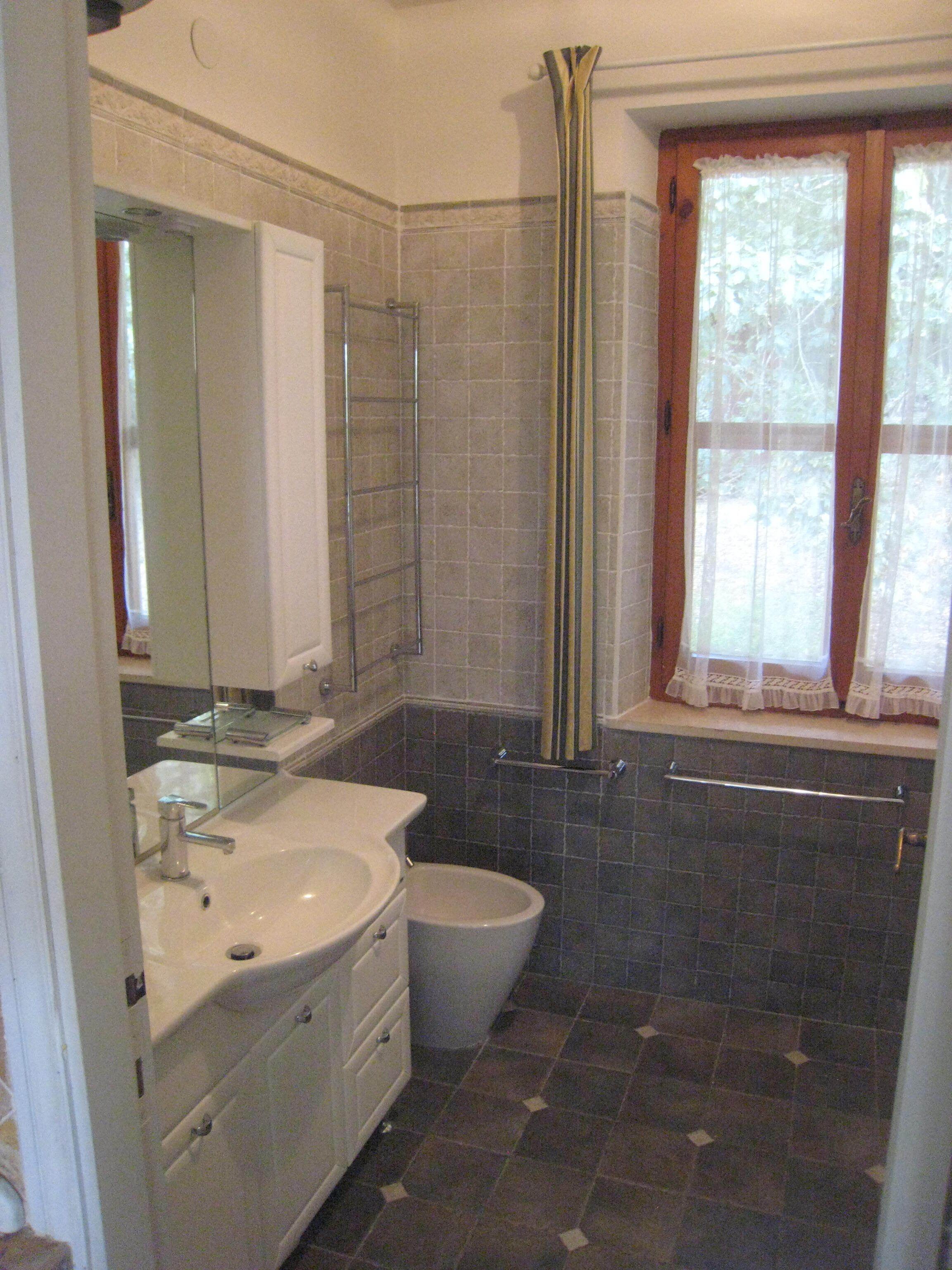 A bathroom with a sink, toilet, and mirror.