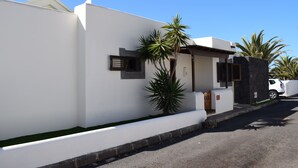 A modern white building with a flat roof, a small porch, and a palm tree in front. - Fantastic villa with completely private pool, with high wall. Free wifi (Playa blanca)
