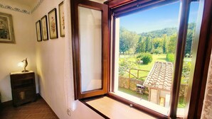 Una habitación con un amplio ventanal que da a un jardín y vistas al campo.