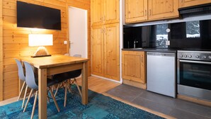 Eine kompakte Küche mit Holzausbau, Backofen und Geschirrspüler.