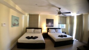 A hotel room with two beds, a ceiling fan, and a window with curtains. - 3BR Home wRooftop by Ideal Experience VR (Fort Lauderdale)