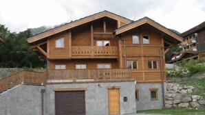 A multi-story wooden chalet with a stone facade, balconies, and a garage. - Chalet - Montgellafrey (Montgellafrey)