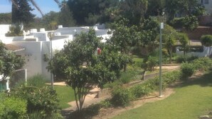 A residential area with white buildings, green lawns, and trees.